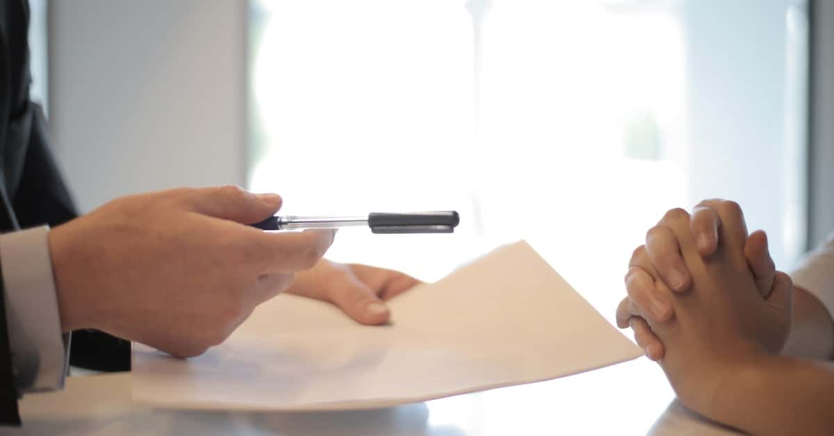 A man in a suit is signing a document related to ecommerce.